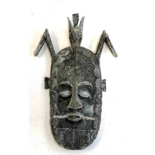 134 - A decorative cast metal tribal mask, 34cmL