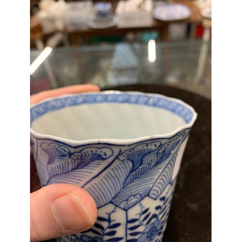 84 - A Chinese blue and white cup decorated with floral panels, marked to base with a flower in double bl... 