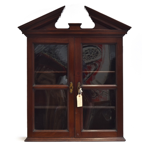 518 - A 19th century mahogany hanging display cabinet, the broken pediment over two glazed doors, opening ... 