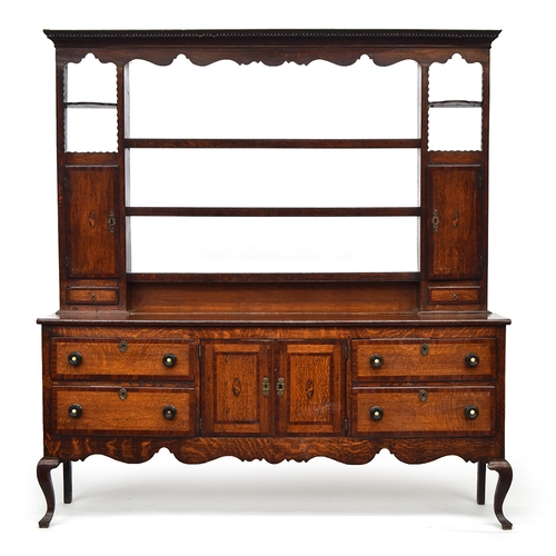 504 - An 18th century oak dresser, the top with dentil cornice over three shelves flanked by mahogany cros... 