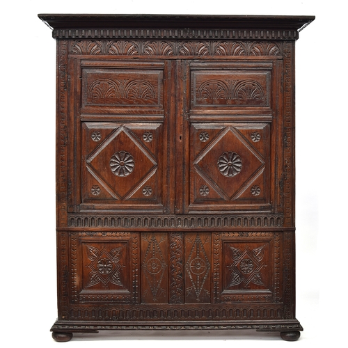 460 - A 17th century and later carved oak cupboard, two doors with lozenge and demilune carving, opening t... 