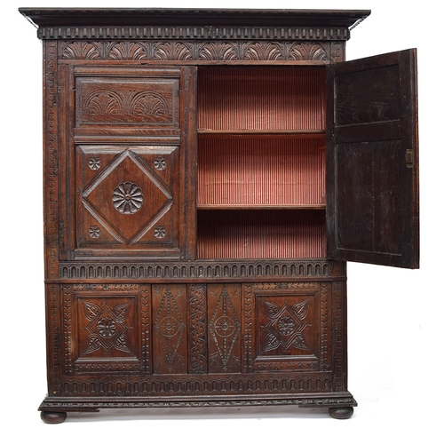 460 - A 17th century and later carved oak cupboard, two doors with lozenge and demilune carving, opening t... 