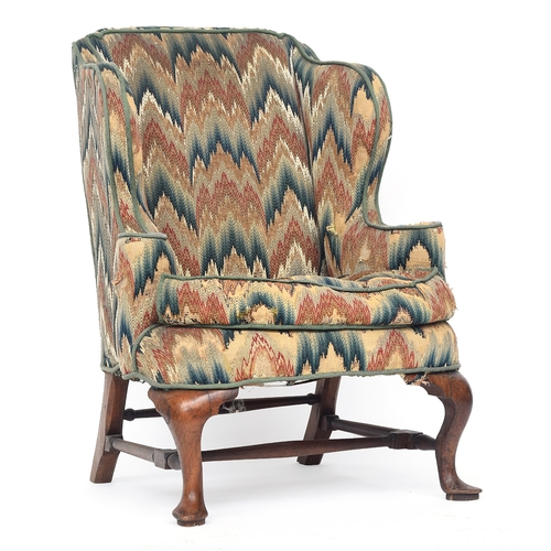 598 - A George I walnut framed wingback armchair, having outward scrolling arms, the cabriole front legs o... 