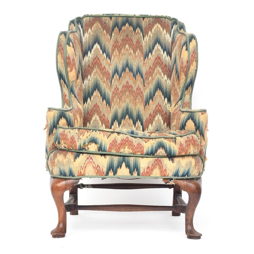 598 - A George I walnut framed wingback armchair, having outward scrolling arms, the cabriole front legs o... 