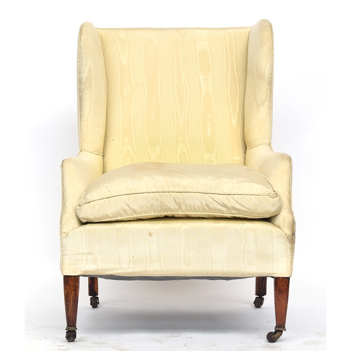 605 - A good wingback armchair, upholstered in watered silk, on square tapered legs with brass caps and ca... 