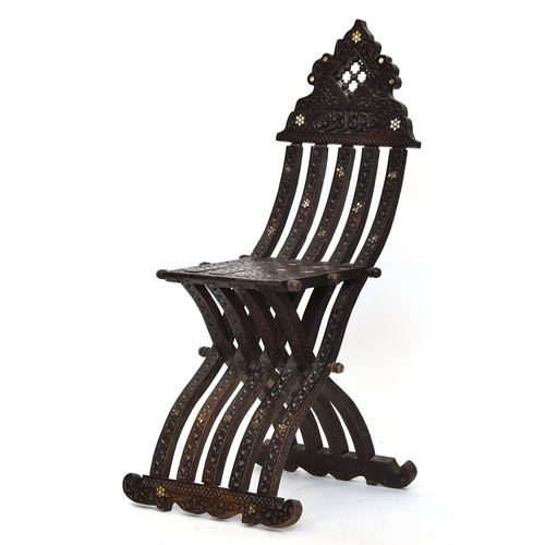 629 - A Syrian folding 'scribe' chair, allover carved with mother of pearl inlay and Arabic script