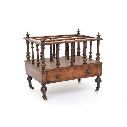 549 - A 19th century mahogany three division Canterbury, turned supports, with single drawer, on ceramic c... 