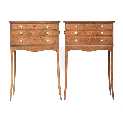 635 - A pair of mahogany cabinets, each with three drawers, with brass carry handles, raised on slender sw... 