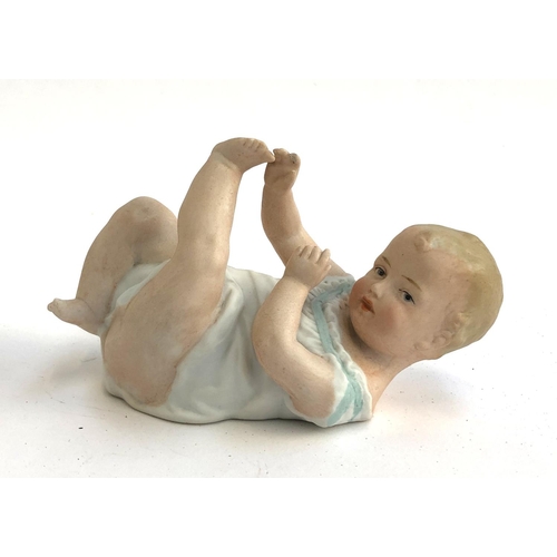 77 - A Gebrüder Heubach bisque porcelain figure of a baby with leg in air, stamped to base, approx. 13.5c... 