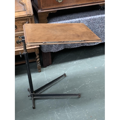 587 - An adjustable invalids table on a cast iron base, the table top 61x45cm