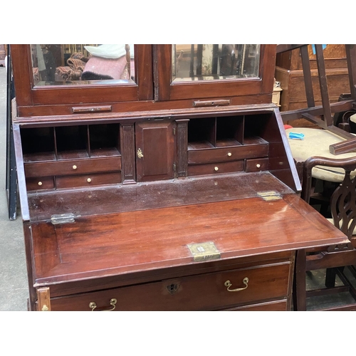 702 - A George III bureau bookcase, c.1760, the mirrored doors opening to an interior of adjustable shelve... 