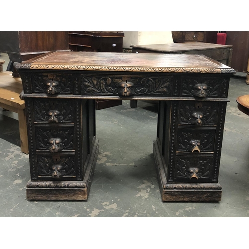 682 - An oak kneehole desk, the drawers carved with lion mask handles (some af), on plinth base, 106x61x75... 