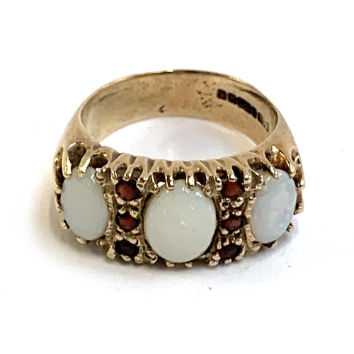 4 - A heavy 9ct gold ring set with opals and garnets, size M 1/2, approx. 6.3g, in an antique ring box