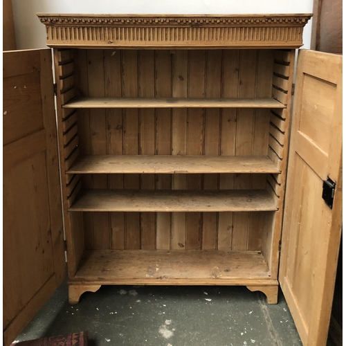 768 - A shallow pine cupboard, with panel doors and three adjustable shelves, one bracket foot detached, 9... 