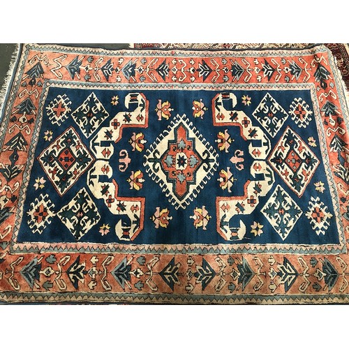 538 - A large wool Persian style rug, central serrated lozenge on a blue ground, 255x185cm