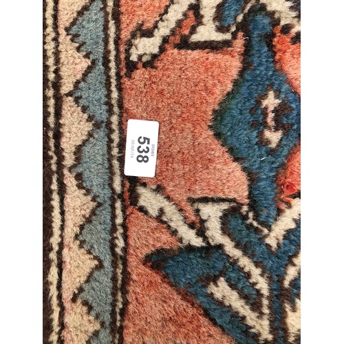 538 - A large wool Persian style rug, central serrated lozenge on a blue ground, 255x185cm