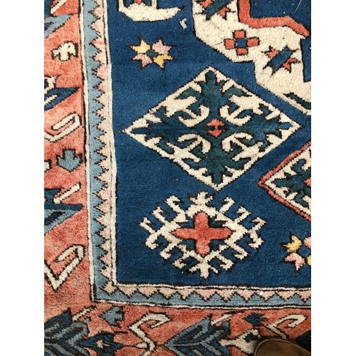 538 - A large wool Persian style rug, central serrated lozenge on a blue ground, 255x185cm