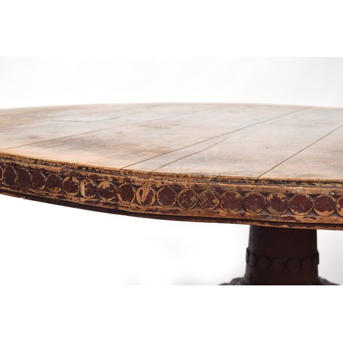 590 - A substantial Indian hardwood dining table, 19th century, the circular top with a carved edge, on a ... 