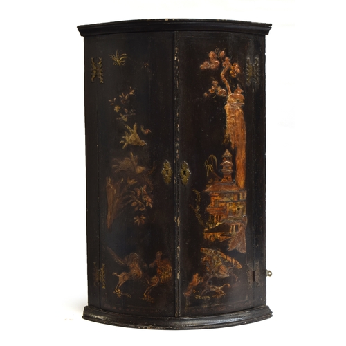 501 - A George III Japanned bowfront corner cupboard, the doors depicting pagodas and foliage, opening to ... 