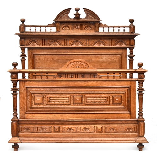 632 - An early 20th century carved oak double bed, broken pediment over demilune carving, the headboard 17... 