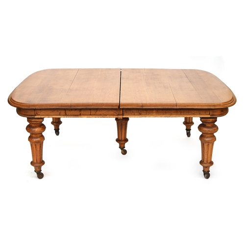 588 - An extremely large extending oak dining table, on five substantial turned and fluted legs, 205cm lon... 