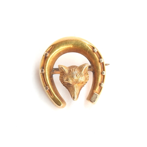 29 - A gold brooch in the form of a fox mask and horseshoe, tests as 14ct or higher, 1.8cm wide, 2.4g; to... 