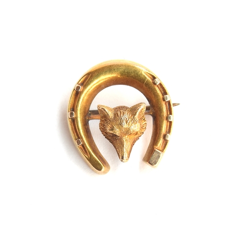 29 - A gold brooch in the form of a fox mask and horseshoe, tests as 14ct or higher, 1.8cm wide, 2.4g; to... 