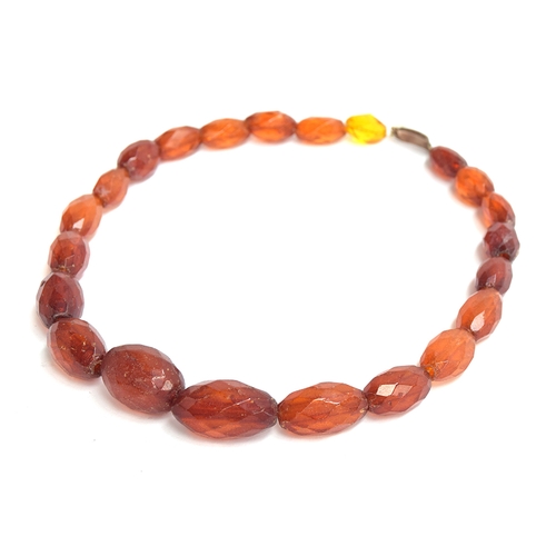 40 - A faceted amber bead necklace, with a 9ct gold clasp, the largest bead 2.7cm long (one bead yellow g... 