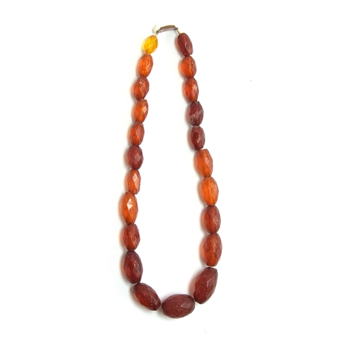 40 - A faceted amber bead necklace, with a 9ct gold clasp, the largest bead 2.7cm long (one bead yellow g... 