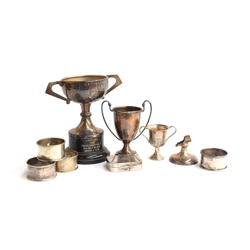 64 - A mixed lot of various silver items, to include several twin handled trophy cups, four napkin rings,... 