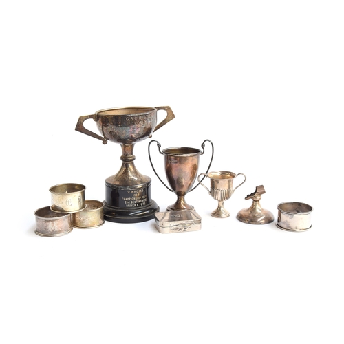 64 - A mixed lot of various silver items, to include several twin handled trophy cups, four napkin rings,... 