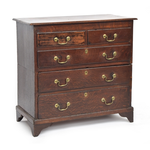 473 - An early 18th century oak chest of two short over three graduating drawers, on bracket feet, cut in ... 