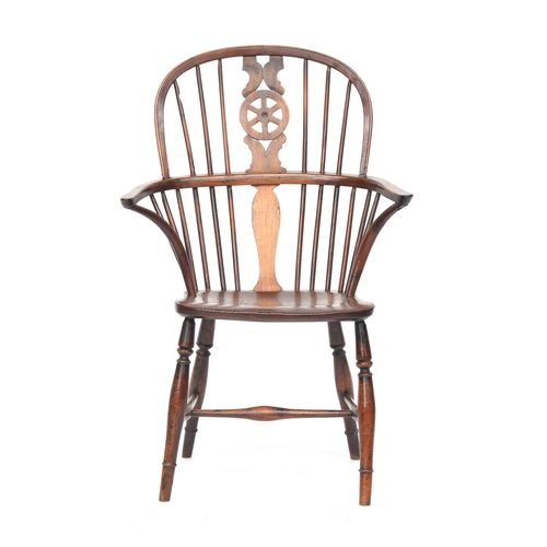 628 - A 19th century yew and elm wheelback Windsor chair, wide set arms on bent front supports, on ring an... 