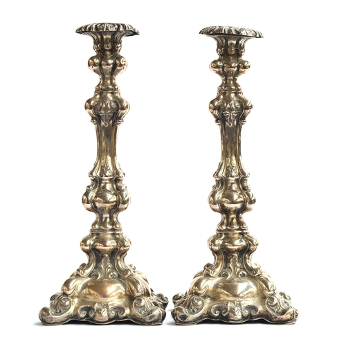 86 - A pair of probably Italian rococo silver candlesticks, with removable nozzles, each 33cm high, 24.9o... 