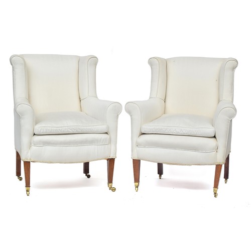 604 - A good pair of small wingback armchairs, early 20th century, on square tapered legs with brass caps ... 