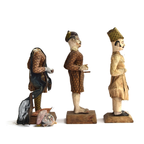 173 - Three late 19th century Indian clay figures of men, in material clothing, some losses, each on a woo... 