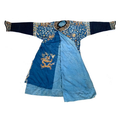 653 - A 19th century Chinese blue silk 'dragon' robe with long sleeves and horse hoof cuffs, detailed with... 