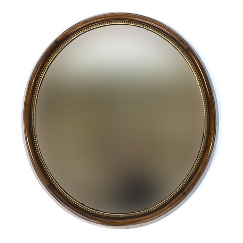 386 - A 19th century oval wall mirror, in a deep walnut frame, with gilt bobble moulded slip, 66cm wide, 7... 