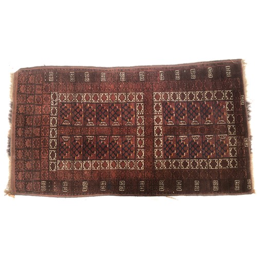 667 - A Turkmen flatweave rug, geometric patterns on a red ground, 122x215cm