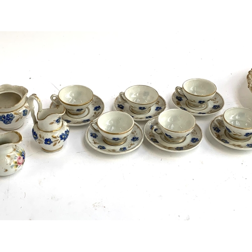 338 - A miniature doll's tea set comprising 6 cups and saucers, jug, together with a 19th century hand pai... 