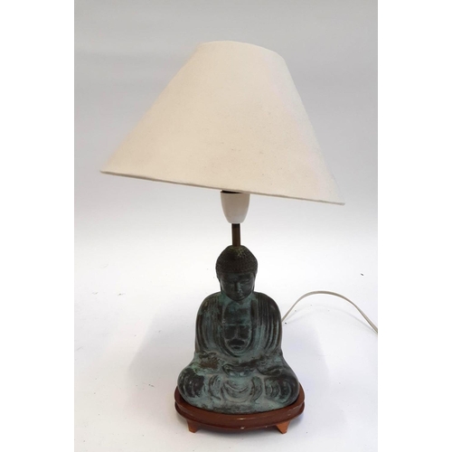 389 - A bronze buddha in the form of a lamp on wooden stand, the buddha 17cmH