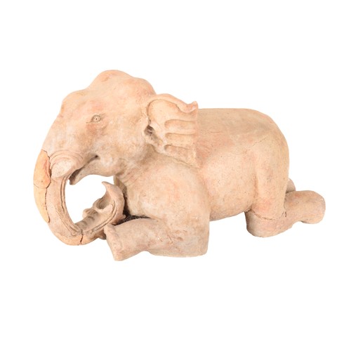 232 - An Indian terracotta elephant, late 19th or early 20th century, modelled kneeling, 33cm high x 55cm ... 