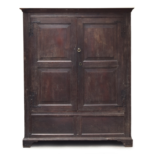 468A - An 18th century provincial oak cupboard, moulded pediment over a pair of panelled doors, opening to ... 