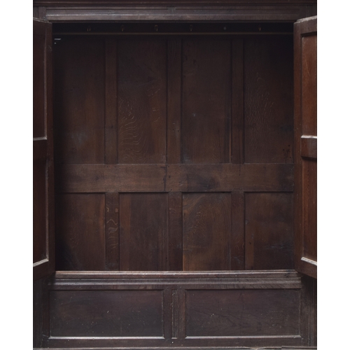 468A - An 18th century provincial oak cupboard, moulded pediment over a pair of panelled doors, opening to ... 