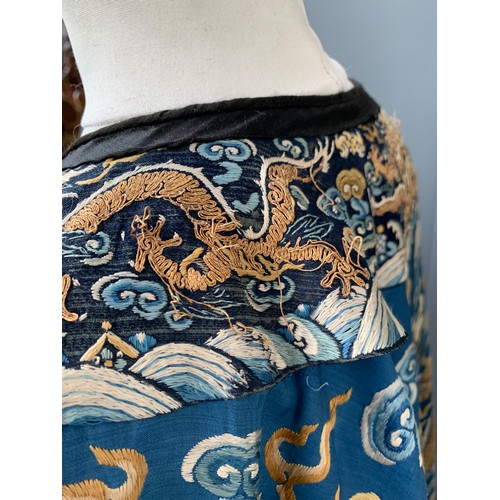 653 - A 19th century Chinese blue silk 'dragon' robe with long sleeves and horse hoof cuffs, detailed with... 