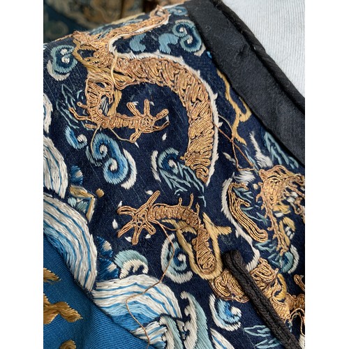 653 - A 19th century Chinese blue silk 'dragon' robe with long sleeves and horse hoof cuffs, detailed with... 