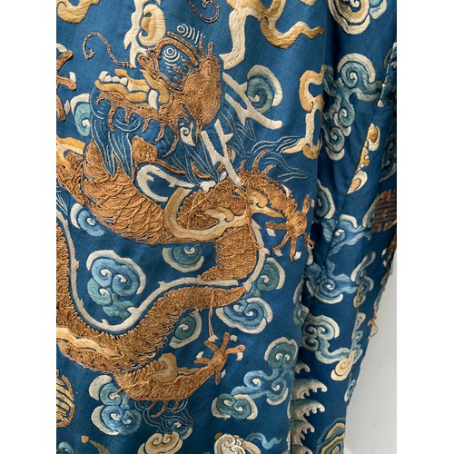 653 - A 19th century Chinese blue silk 'dragon' robe with long sleeves and horse hoof cuffs, detailed with... 