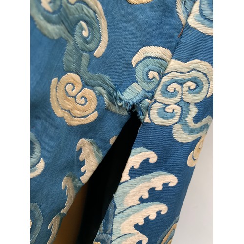 653 - A 19th century Chinese blue silk 'dragon' robe with long sleeves and horse hoof cuffs, detailed with... 