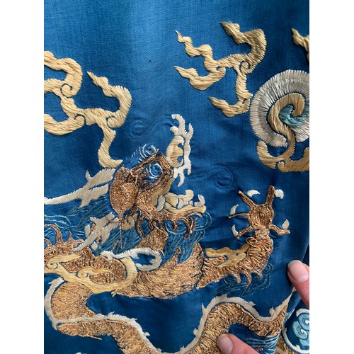 653 - A 19th century Chinese blue silk 'dragon' robe with long sleeves and horse hoof cuffs, detailed with... 