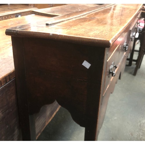 506 - An 18th century oak dresser base, three drawers over a shaped apron, on chamfered square section leg... 